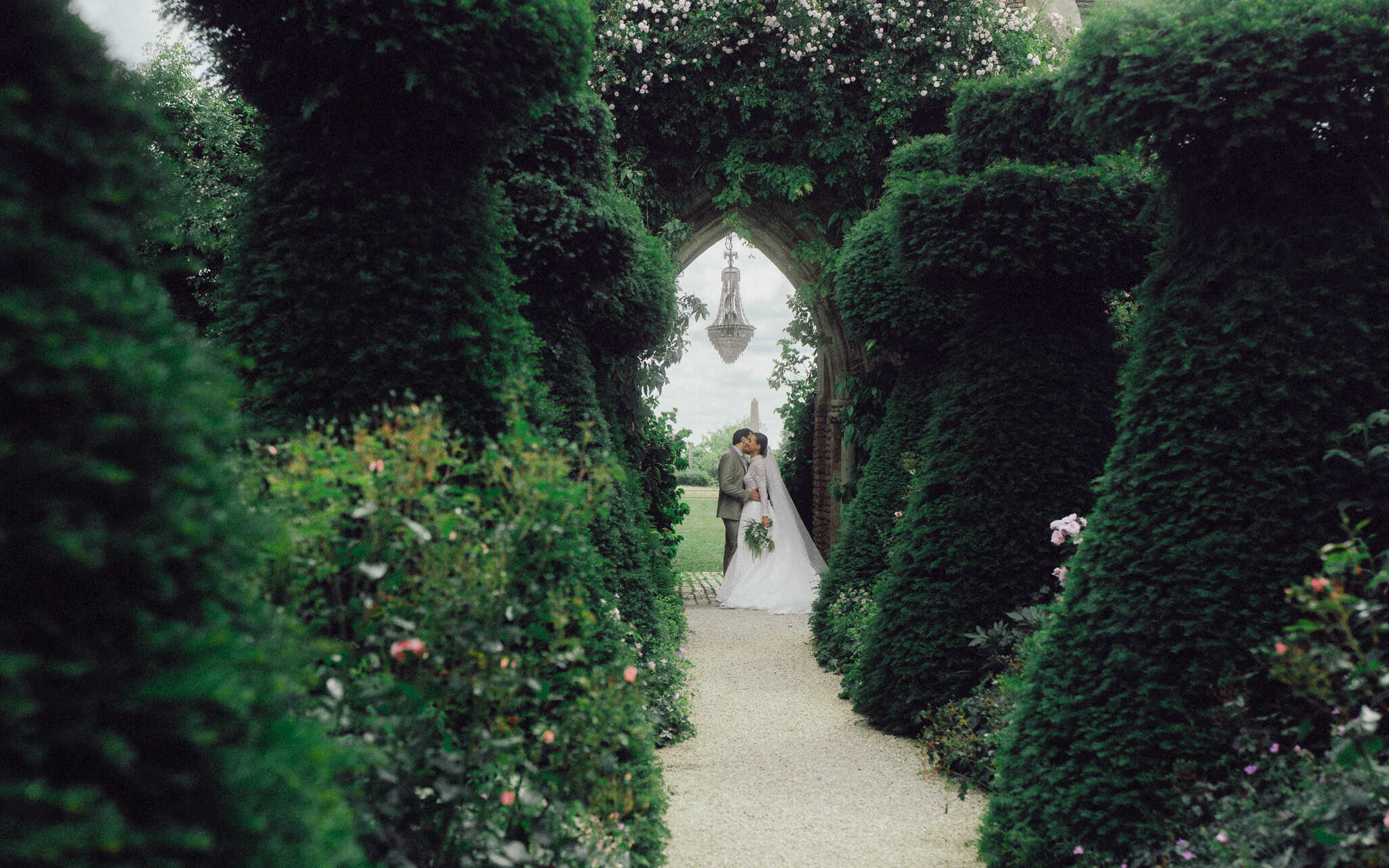 Bride and groom sharing a quiet moment in a garden at Euridge Manor, captured in a cinematic, natural-light wedding portrait.