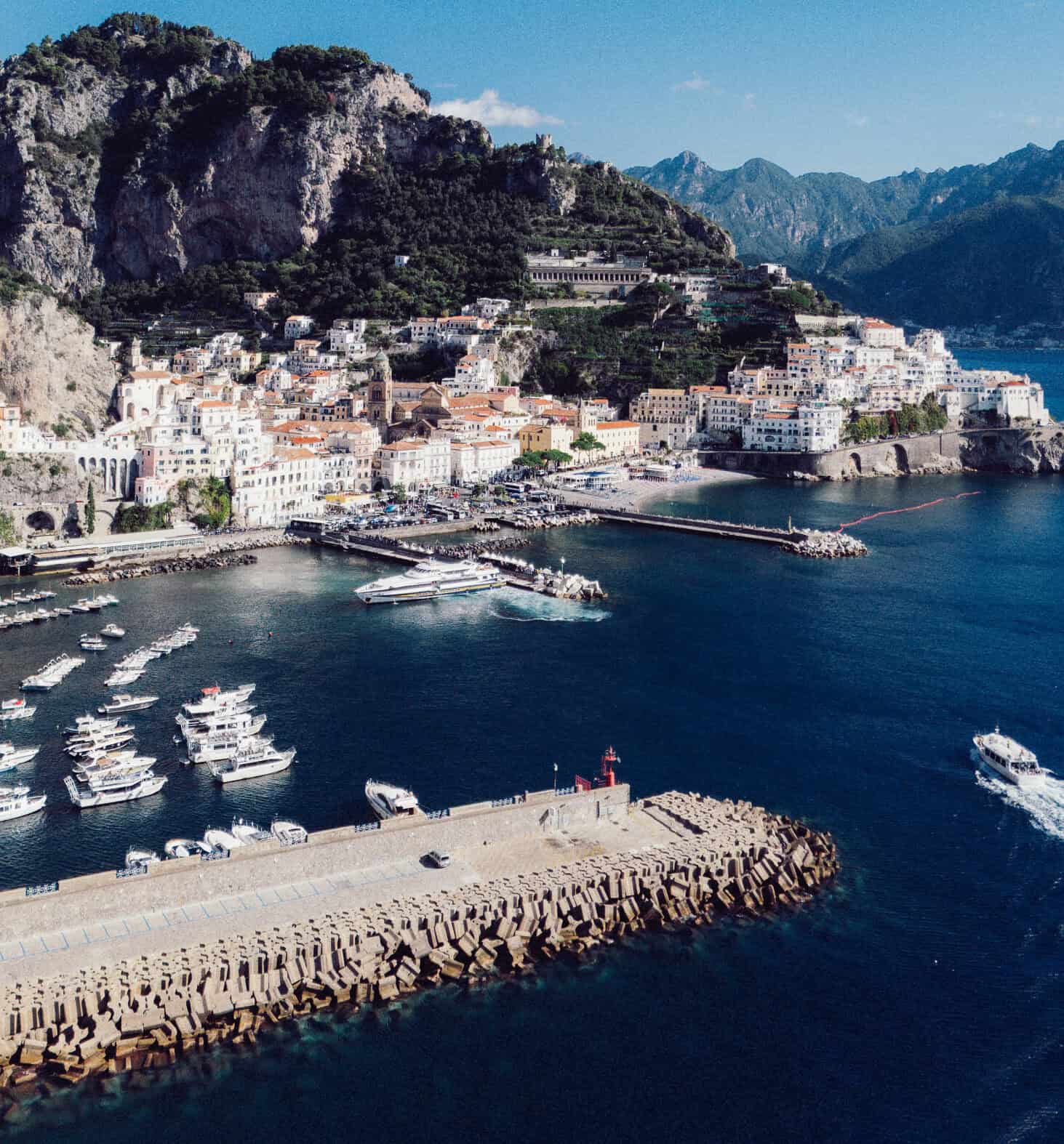 Beautiful Amalfi Coast harbor with colorful buildings and yachts.