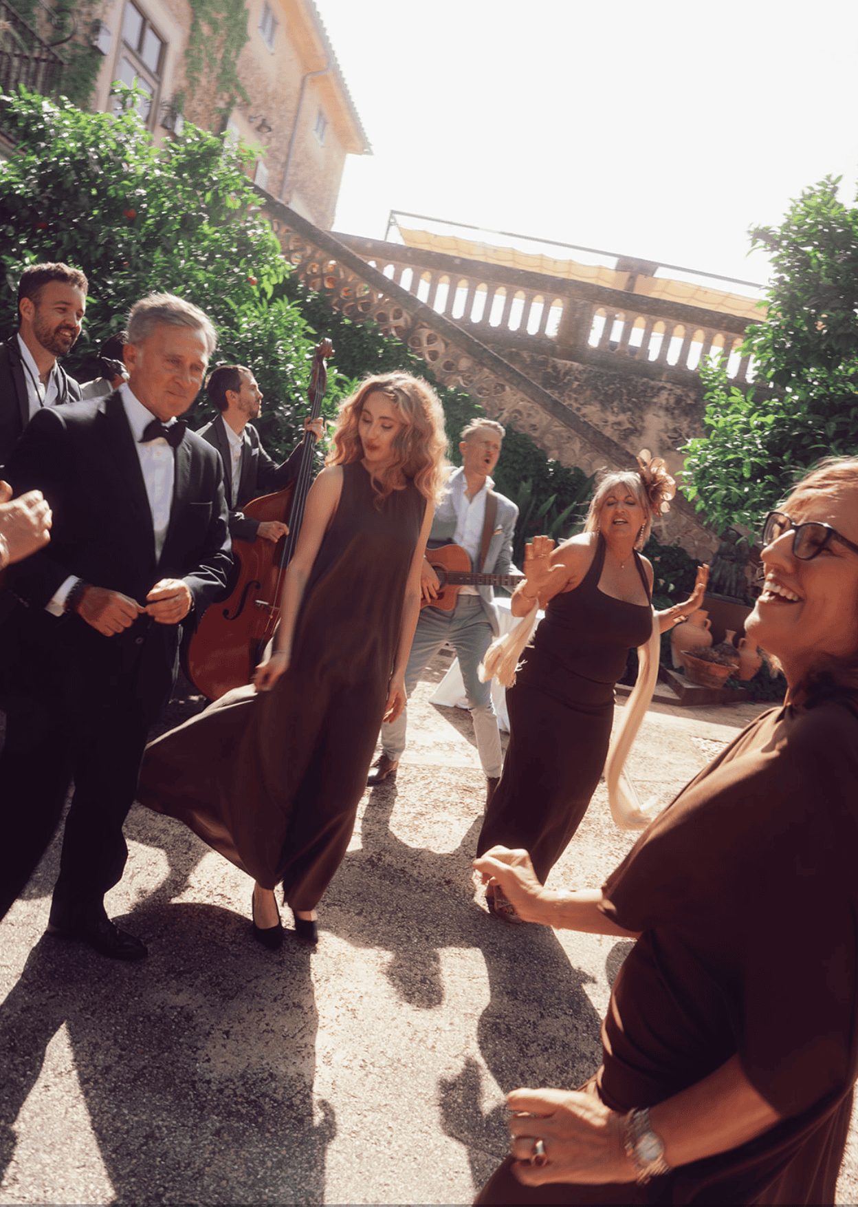 Wedding guests arriving at an outdoor ceremony in Italy, dressed in elegant summer attire