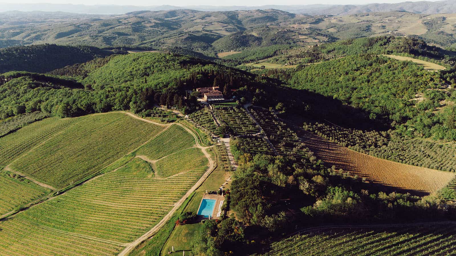 Aerial view of a Tuscan wedding venue surrounded by rolling hills in Italy